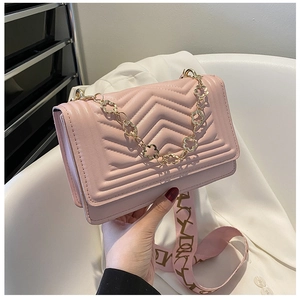 Detailed side view of pink quilted shoulder bag with gold floral chain and floral strap