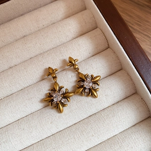 Detailed view of vintage iris flower earrings with zircon in retro gold finish