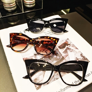 Set di occhiali da sole cat eye oversize in nero e tartarugato su una rivista di moda