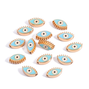 Macro view of 10mm golden alloy evil eye charms with blue enamel details for jewelry