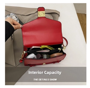 Detail view of red shoulder bag interior compartments with gold buckle and storage space