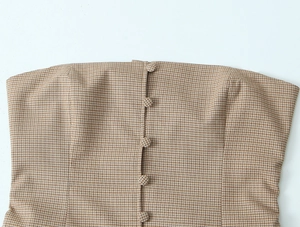 Detailansicht des braun karierten Schlauchoberteils mit vorderer Knopfleiste und Textur
