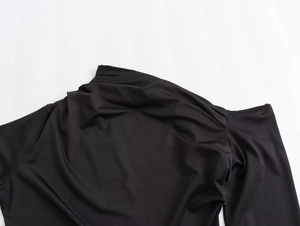 Detail shot of the asymmetric neckline and smooth nylon fabric on this black maxi dress
