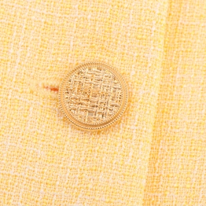 Giacca da donna in tweed giallo con dettaglio del bottone dorato con texture premium
