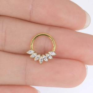 Detailed close-up of a gold F136 titanium nose ring featuring seven marquise cut zircons