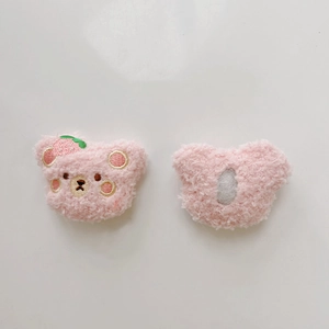 Detailed front and back view of pink plush bear pins with strawberry embroidery
