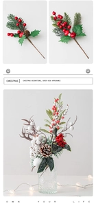 Close-up of red berries and pine needles in a glass vase with warm lights