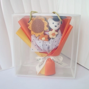 Detail of crochet graduation bouquet featuring a bear in a cap and knitted sunflower