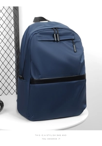 Blue nylon business backpack on a pedestal showcasing the front zipper pocket and sleek design