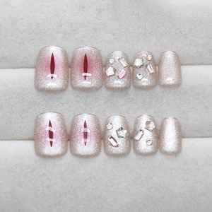 Star-shaped rhinestone cat-eye press-on nails in pink and red theme with hand-painted details