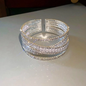 Detailopname van de zilveren gelaagde armband met glinsterende kristallen en parels
