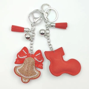 Detailed view of Christmas bell and stocking keychains with rhinestones and red tassels