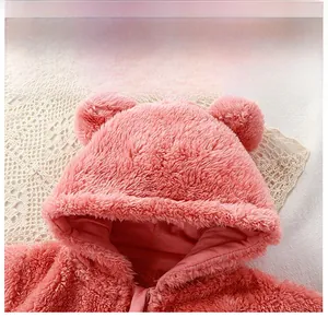 Détail de la combinaison bébé à capuche rose avec oreilles et tissu polaire doux