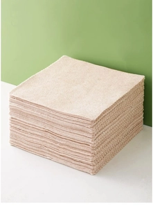 Close-up of stacked beige loofah fiber dishcloths with high-absorbent texture
