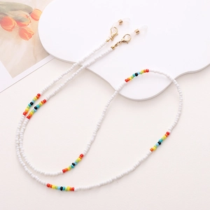 Detail of beaded glasses chain with white seed beads, colorful accents and golden clasps