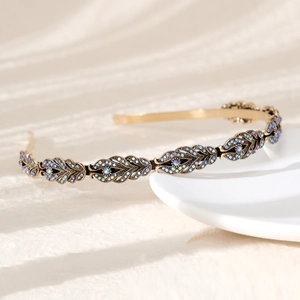 Detail of golden leaf headband with colorful rhinestones on a white plate