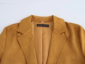 Détail du revers à encoche et de la texture en daim doux sur ce blazer jaune moutarde