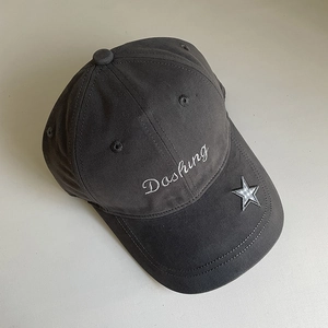 Detail of white Dashing embroidery and star patch on dark gray cotton baseball cap