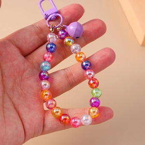 Close-up of colorful iridescent beads with purple bell and plastic clasp keychain