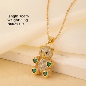 Detailed close-up of a gold-plated bear pendant necklace with green heart zirconia