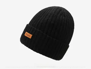 Close-up of black ribbed knit beanie featuring a brown leather patch with NY&JA text