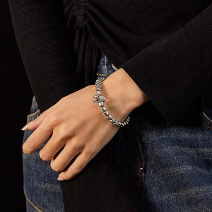 Detail of silver crown charm beaded stainless steel bracelet worn on female wrist
