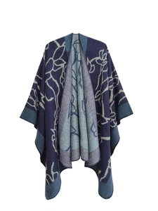 Detail of dark blue knit poncho with white floral jacquard pattern and overlocked edges