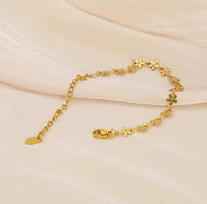 Macro detail of gold daisy bracelet with turquoise enamel on silky fabric