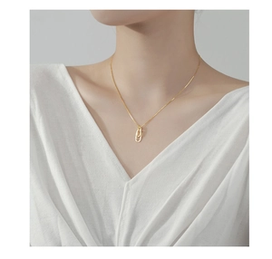 Close-up of golden S925 silver necklace with interlocking double ring pendant on neck
