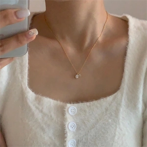 Close-up of elegant double water-drop zircon pendants on a delicate gold chain necklace