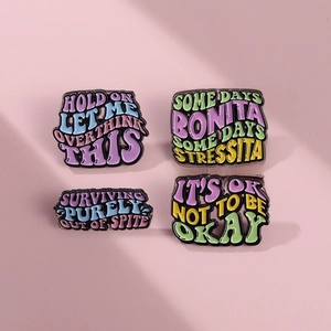 Lot de 4 pin's émaillés colorés avec slogans anglais humoristiques sur fond rose