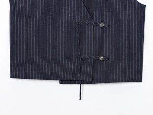 Detailed close-up of navy blue pinstripe linen vest showing the double button closure
