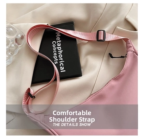 Detailed view of the pink nylon crossbody bag showing the thick strap and plastic buckle