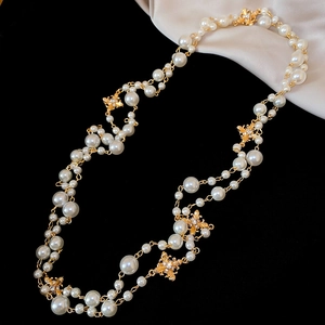 Detail of French vintage pearl necklace featuring golden bees and sparkling rhinestones