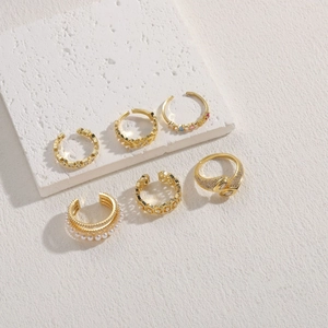 Goldenes sechsteiliges Schmuckset mit Perlen und Zirkonia auf weißem Stein