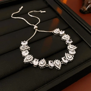 Detailed view of silver adjustable bracelet with leaf pattern and oval cubic zirconia stones