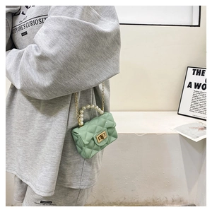 Detail view of mint green jelly bag featuring quilted texture and pearl chain handle