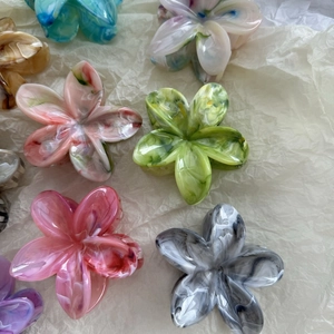 Detailed flat lay of floral hair claws with marble texture in various pastel colors