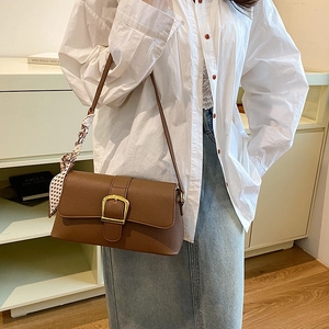 Brown lychee grain leather bag with golden D-ring buckle and beige polka dot scarf detail