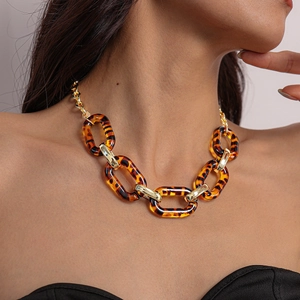 Close-up of tortoise shell resin and gold metal chunky link necklace on model