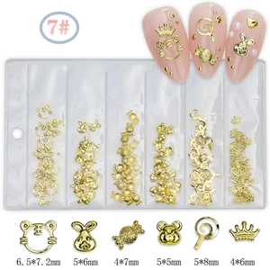 Golden metal nail art charms set with sizes shown in a six-grid organizer box