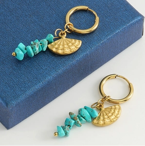 Detail of turquoise fan drop earrings with golden rings and beaded stones in vintage style