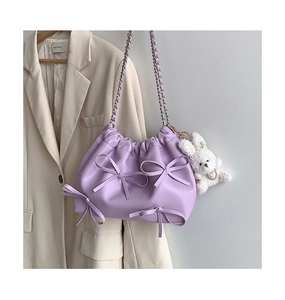 Detail of purple soft PU leather shoulder bag with 3D bows and a plush bunny charm