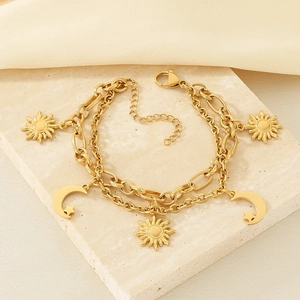 Detail of 18K gold-plated double-layer bracelet with sun and moon charms on stone base