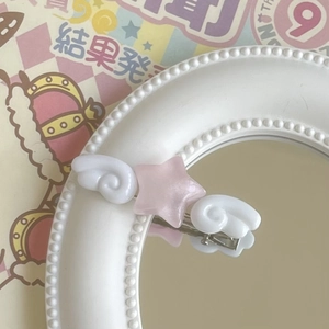 Close-up of pink star hair clip with angel wings on a decorative kawaii background