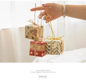 Close-up of three festive mini Christmas gift boxes with red, gold and kraft paper designs