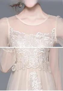 Détails de broderie sur une robe en dentelle champagne aux motifs floraux élégants