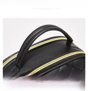 Detail einer schwarzen gesteppten Lederhandtasche mit zwei goldenen Reißverschlüssen