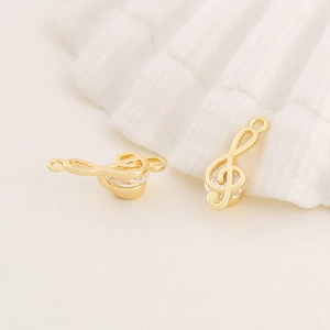 Macro shot of gold musical note pendant with sparkling zircon inlays on shell background