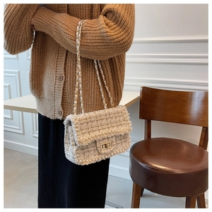 Detail showing tweed texture and double pearl decoration on white crossbody chain bag